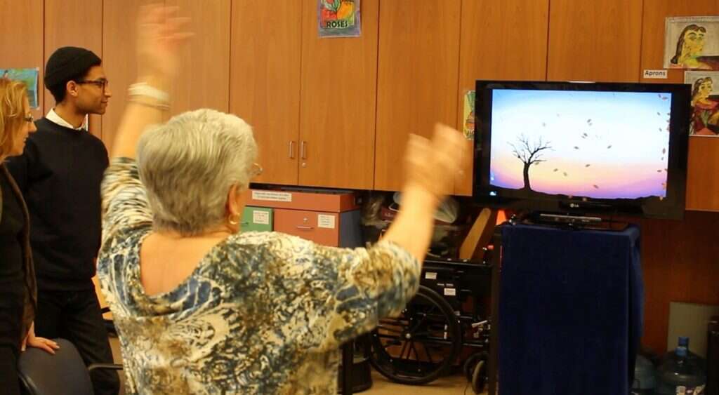 An elderly participant is interacting with the motion-based ABLE software.