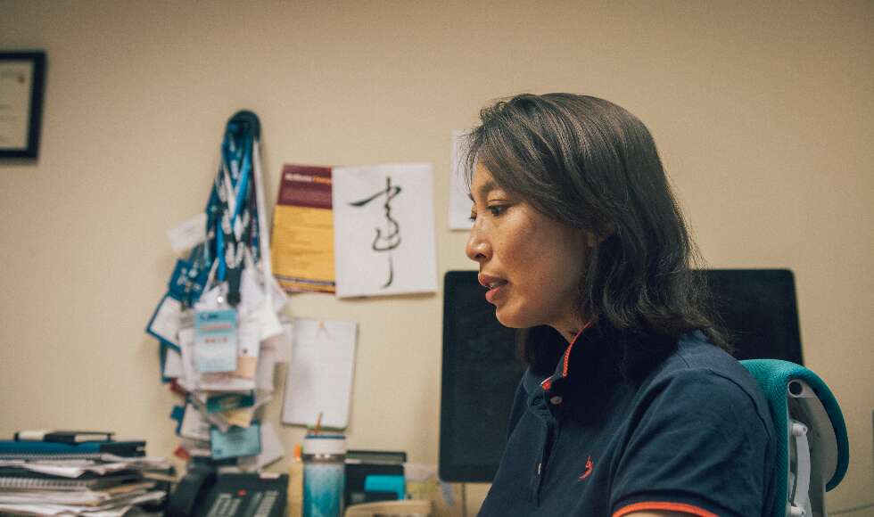 Dr. Rong Zheng sits at her desk in her office